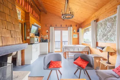 a kitchen and living room in a log cabin at L'Écrin des Anges Chalet cosy, Ski et Vue in Combloux