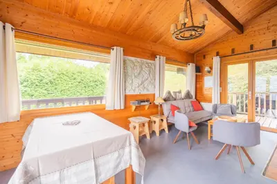 a living room with a table and a couch at L'Écrin des Anges Chalet cosy, Ski et Vue in Combloux