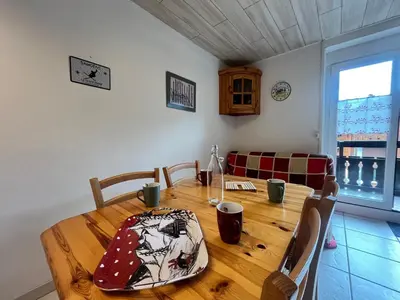 a wooden table in a living room with a table and chairs at Charmant T2 Mezzanine au Centre de Samoëns avec Balcon, WIFI - FR-1-624-182 in Samoëns