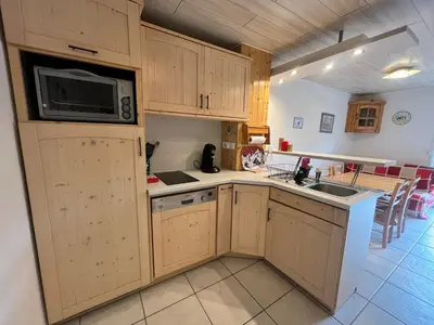 a kitchen with wooden cabinets and a microwave at Charmant T2 Mezzanine au Centre de Samoëns avec Balcon, WIFI - FR-1-624-182 in Samoëns