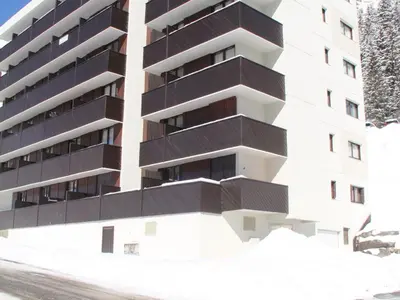 an apartment building with black balconies and a road at Appartement rénové 3 pièces · Balcon sud · WIFI gratuit · Flaine Forêt - FR-1-425-236 in Arâches-la-Frasse