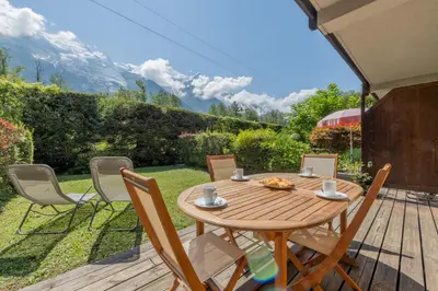 a bathroom with a toilet with a wooden door at Appartement Les Capucins jardin - Happy Rentals in Chamonix-Mont-Blanc