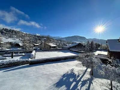 a snow covered yard with the sun in the background at Séjour lumineux avec vue sur les cimes in Megève