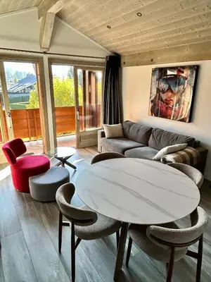 a living room with a couch and a table and chairs at Séjour lumineux avec vue sur les cimes in Megève