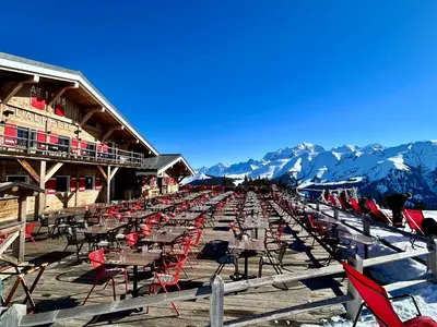 a long row of tables and chairs in front of a building at Séjour lumineux avec vue sur les cimes in Megève