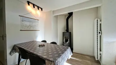 a room with a table with chairs and a stove at Résidence Doris - Appartement rénové · Centre station · Balcon · WIFI gratuit MAE-4483 in Magland