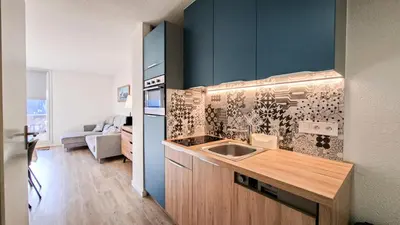 a kitchen with a sink and a blue wall at Résidence Doris - Appartement rénové · Centre station · Balcon · WIFI gratuit MAE-4483 in Magland