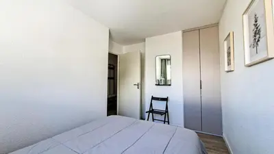 a bedroom with a bed and a chair in it at Résidence Doris - Appartement rénové · Centre station · Balcon · WIFI gratuit MAE-4483 in Magland