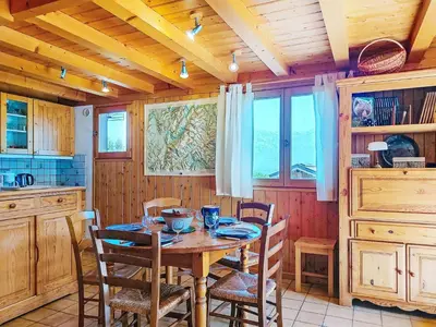 a kitchen with a wooden table with chairs and a wooden ceiling at Holiday Home Les Chalets de La Combe by Interhome in Mémontel