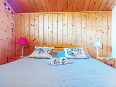 a bedroom with wooden walls and a bed with a stuffed animal at Holiday Home Les Chalets de La Combe by Interhome in Mémontel