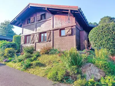 a picnic table with an umbrella on a wooden deck at Holiday Home Les Chalets de La Combe by Interhome in Mémontel