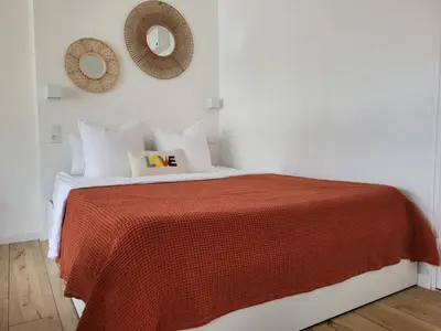 a bedroom with a bed with a red blanket and a mirror at Studio cosy & rénové, à deux pas de la gare in Sallanches