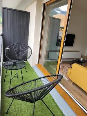 a balcony with a chair and a table at Studio cosy & rénové, à deux pas de la gare in Sallanches