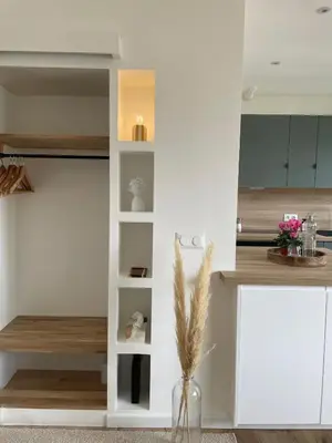 a kitchen with white cabinets and a vase with flowers at Studio cosy & rénové, à deux pas de la gare in Sallanches