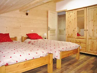a bedroom with a large bed with red pillows at Chalet confortable pour 10 pers à Samoëns avec parking et terrasse - FR-1-815-47 in Samoëns