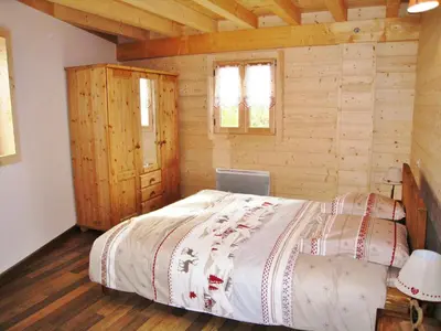 a bedroom with a large bed in a log cabin at Chalet confortable pour 10 pers à Samoëns avec parking et terrasse - FR-1-815-47 in Samoëns