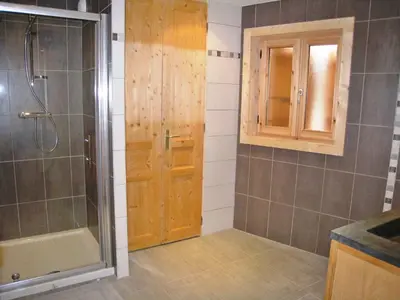 a bathroom with a shower and a wooden door at Chalet confortable pour 10 pers à Samoëns avec parking et terrasse - FR-1-815-47 in Samoëns