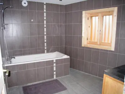 a bathroom with a bath tub and a window at Chalet confortable pour 10 pers à Samoëns avec parking et terrasse - FR-1-815-47 in Samoëns