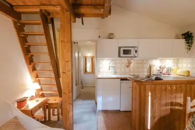 a kitchen with white cabinets and a wooden staircase at Charming apartment in Chamonix in Chamonix-Mont-Blanc