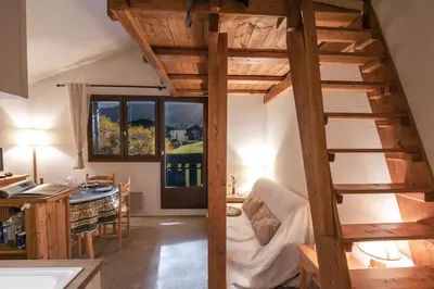 a room with a loft bed and a kitchen at Charming apartment in Chamonix in Chamonix-Mont-Blanc
