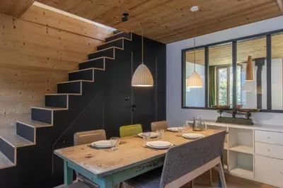 a dining room with a wooden table and a staircase at Le Nevada - Duplex T4 Proche Centre in Chamonix-Mont-Blanc