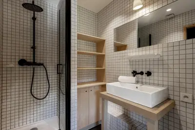 a white tiled bathroom with a sink and a shower at Le Nevada - Duplex T4 Proche Centre in Chamonix-Mont-Blanc