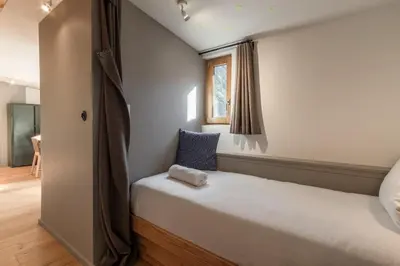 a small bedroom with a bed and a window at Le Nevada - Duplex T4 Proche Centre in Chamonix-Mont-Blanc