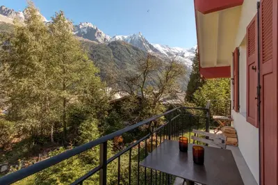 a balcony with a bench and mountains in the background at Le Nevada - Duplex T4 Proche Centre in Chamonix-Mont-Blanc