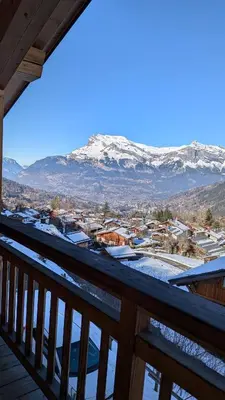 a view from a balcony of a town with snow covered mountains at Le Chalet MontBlanc in Bionnay