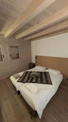 a large bed in a room with a wooden ceiling at Le Chalet MontBlanc in Bionnay
