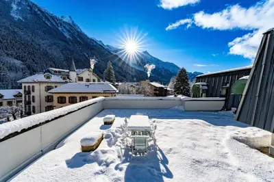 a snow covered balcony with a view of a mountain at Hyper central apartment with rooftop in Chamonix-Mont-Blanc