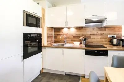 a kitchen with white cabinets and a sink at Unique appartement 2 chambres derniere etage Les Terrasses dEos in Flaine