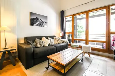 a living room with a couch and a table at Unique appartement 2 chambres derniere etage Les Terrasses dEos in Flaine