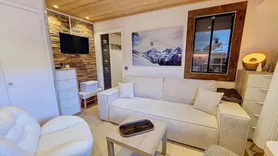 a living room with a couch and a tv at 1 Farniente in Megève