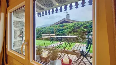 a window view of a patio with a table and chairs at 1 Farniente in Megève