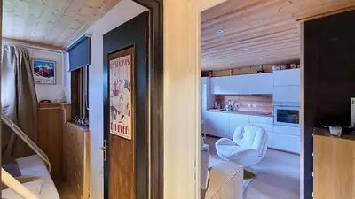 a kitchen with a white chair in a room at 1 Farniente in Megève