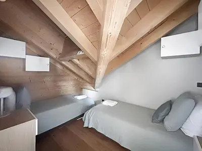 a room with two beds and a wooden ceiling at DBA302 Appartement standing 6 pers in Les Carroz d'Araches