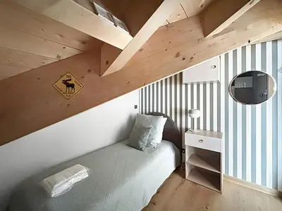 a small bedroom with a bed and a wooden ceiling at DBA302 Appartement standing 6 pers in Les Carroz d'Araches