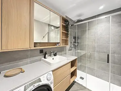 a bathroom with a sink and a washing machine at DBA302 Appartement standing 6 pers in Les Carroz d'Araches