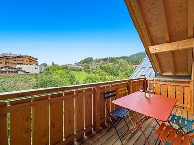 a balcony with a red table and chairs on it at DBA302 Appartement standing 6 pers in Les Carroz d'Araches