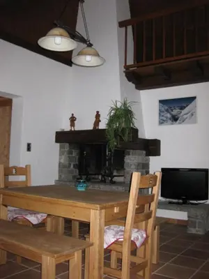 a dining room with a table and a fireplace at Appartement Léa in Chamonix-Mont-Blanc