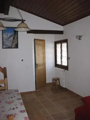 a room with a door and a table and a stool at Appartement Léa in Chamonix-Mont-Blanc