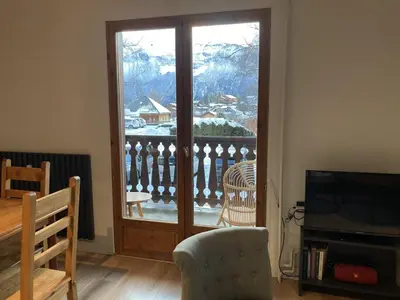 a living room with a sliding glass door with a balcony at 3 PIECES résidence LA POINTE PERCEE - FR-1-572-207 in Arâches-la-Frasse