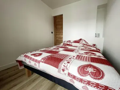 a bedroom with a bed with a red and white quilt at 3 PIECES résidence LA POINTE PERCEE - FR-1-572-207 in Arâches-la-Frasse
