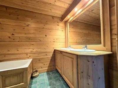 a wooden bathroom with a sink and a tub at Chalet near centre of Megève in Megève