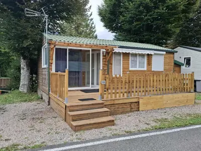 a wooden cabin with a porch and a deck at Mobil home 4 personnes au pied du Grand Massif à Samoëns in Samoëns