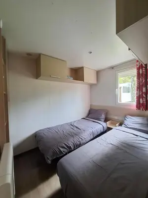 a bedroom with two beds and a window at Mobil home 4 personnes au pied du Grand Massif à Samoëns in Samoëns