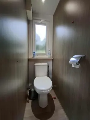 a small bathroom with a toilet and a window at Mobil home 4 personnes au pied du Grand Massif à Samoëns in Samoëns