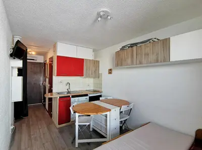 a small kitchen with a table and a counter top at Studio Samoens 1600 pied des pistes in Samoëns