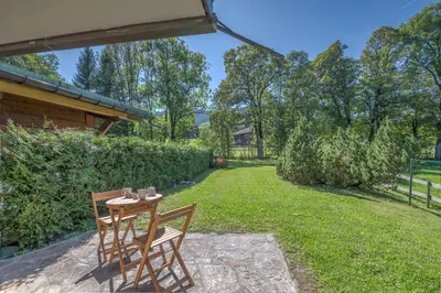 a patio with two chairs and a table in a yard at Appartement Pruniers - Welkeys in Megève